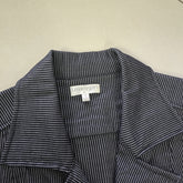 Close-up of a striped garment with a visible label on a beige background